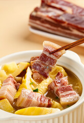 Asian Soup with Smoked Bacon and Pickled Vegetables in Traditional White Bowl with Chopsticks