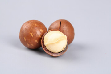 Macadamia Nuts with Cracked Shell Showing Cream Kernel on Light Background