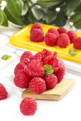 Freshly Picked Red Raspberries on Wooden Board with Shallow Depth of Field