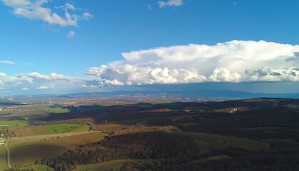 Vast Landscape Under a Dramatic Sky with a Large Cloud Formation.