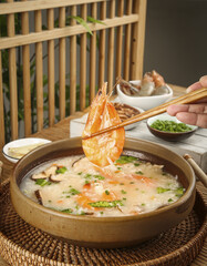 Chinese Seafood Congee with Shrimp - Traditional Asian Rice Porridge Breakfast in Clay Pot