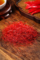 Naklejka premium Red Chili Pepper Shreds and Bell Peppers on Wooden Board - Spice Cooking Ingredients