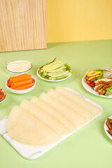 Whole wheat tortillas and fresh breakfast burrito ingredients on colorful background