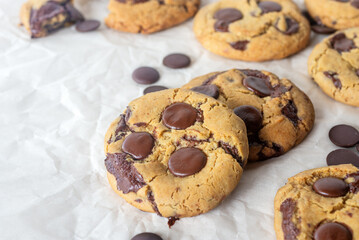 freshly baked homemade chocolate chip cookies on baking paper background
