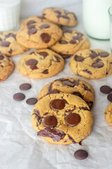 freshly baked homemade chocolate chip cookies on baking paper background