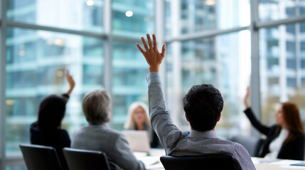 Close-up of a raised hand among a diverse group of people during a meeting or workshop.

