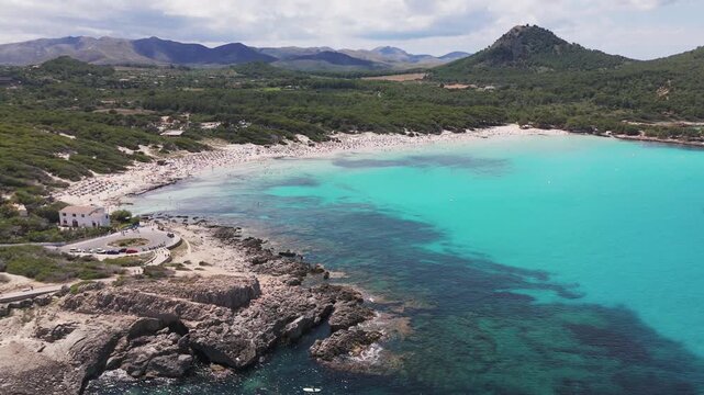 Aerial Drone Pan Of Cala Agulla Beach And Bay With Clear Blue Water And Forest In Mallorca, Spain