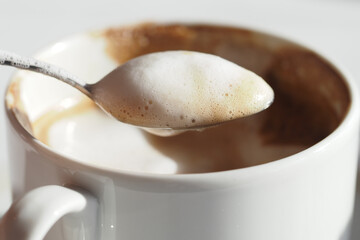 Delicious creamy coffee served in a white mug