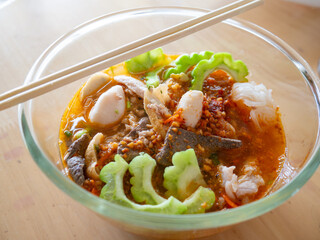 Traditional Thai Tom Yum Noodle Soup with Pork, Meatballs, Dried Shrimp and Pork Liver in Authentic Local Style Street Food Cuisine.