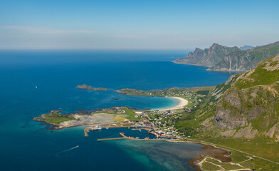 Naklejka premium View from Volandstinden peak towards Ramberg beach and village. Stunning view on beautiful islands. Mountains in background. Fjords and ocean. Arctic Norway, Lofoten. Hiking Lofoten, travel destinatio