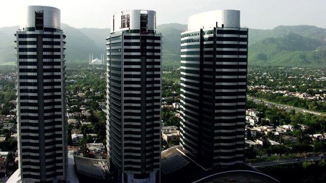 This high-resolution aerial photograph captures the Centaurus Mall complex in Islamabad, Pakistan, featuring three modern skyscrapers with curved glass facades.
