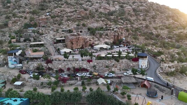Aerial view circling a hillside town, sunny evening in Taif, Saudi Arabia