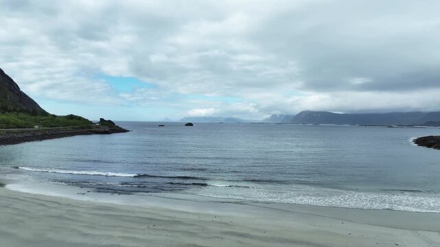 Waves breaking Rorvik Beach in Lofoten, Norway, small waves breaking on sand, slow motion, tracking left to right.