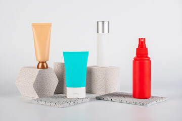 Plastic white tube for cream or lotion. Skin care or sunscreen cosmetic, Cosmetic red bottle. Womens cosmetic accessory for makeup with stylish props on white background.