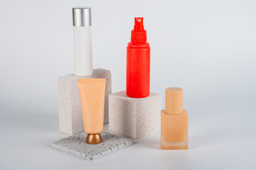 Plastic white tube for cream or lotion. Skin care or sunscreen cosmetic, Cosmetic red bottle. Womens cosmetic accessory for makeup with stylish props on white background.