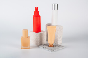 Plastic white tube for cream or lotion. Skin care or sunscreen cosmetic, Cosmetic red bottle. Womens cosmetic accessory for makeup with stylish props on white background.