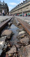 Old railway track embedded in cobblestones, water pooling in the groove