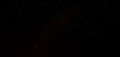 Obraz premium Warm golden light illuminates a dark night sky, twinkling stars subtly visible, bokeh, abstract