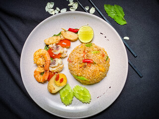 Thai seafood fried rice with shrimp, squid, and mussels stir-fried with jasmine rice, eggs, and aromatic seasonings for a savory flavor.