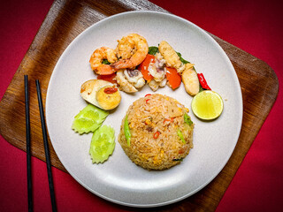Thai seafood fried rice with shrimp, squid, and mussels stir-fried with jasmine rice, eggs, and aromatic seasonings for a savory flavor.