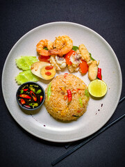 Thai seafood fried rice with shrimp, squid, and mussels stir-fried with jasmine rice, eggs, and aromatic seasonings for a savory flavor.