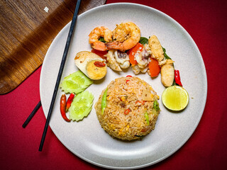 Thai seafood fried rice with shrimp, squid, and mussels stir-fried with jasmine rice, eggs, and aromatic seasonings for a savory flavor.