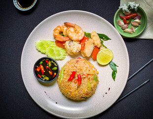 Thai seafood fried rice with shrimp, squid, and mussels stir-fried with jasmine rice, eggs, and aromatic seasonings for a savory flavor.