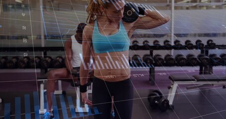 A fit woman lifting dumbbells at a crossfit session in the gym - Powered by Adobe
