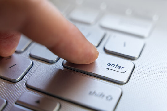 Finger Pressing Enter Key On Laptop Keyboard Close Up