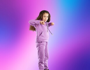 Happy young girl dancing on color background