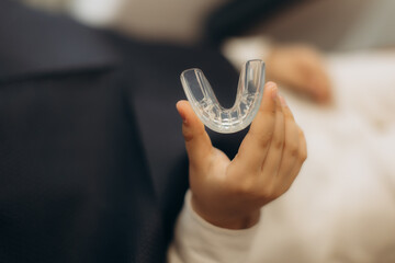 Patient holding transparent dental guard for teeth protection