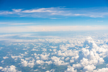 View from airplane window showing aircraft engine, blue sky, and white clouds