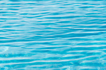 Bright light blue water surface with shimmering wave reflections, abstract liquid texture