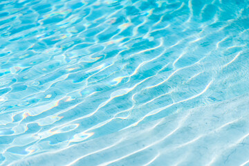 Bright light blue water surface with shimmering wave reflections, abstract liquid texture