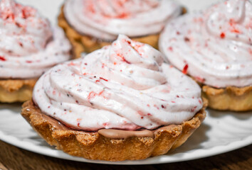 Mini sweet tarts filled with raspberry and strawberry cream, close-up