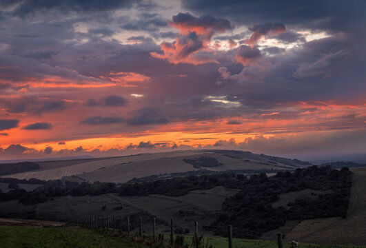 Sunset over Folkington  hill on the south downs from Butts Brow east Sussex south east England UK