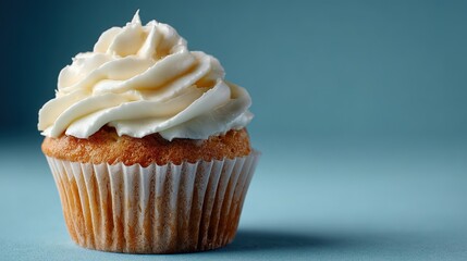 single cupcake with swirls of white frosting against  soft blue background