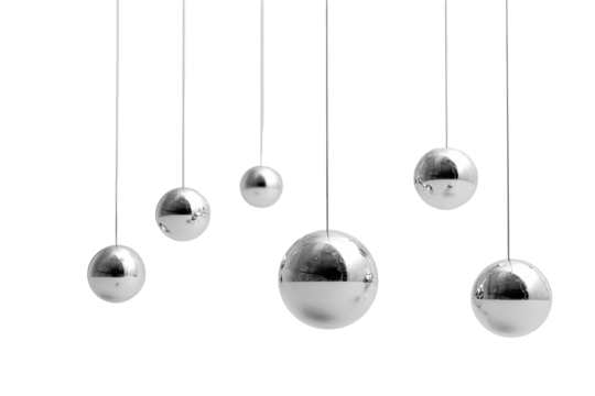 Polished metal spheres hanging on strings against a dark background