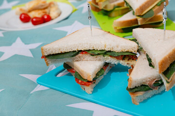 Triangular sandwiches with vegetables served on colorful star-patterned tablecloth