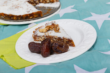 Traditional baklava pastry with nuts coconut and dates on decorative plate