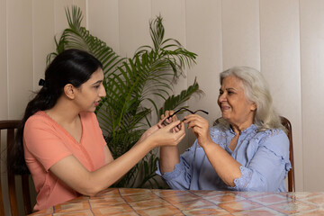 Indian granddaughter happily gifting and showing spectacles to grandmother enjoying moments with...