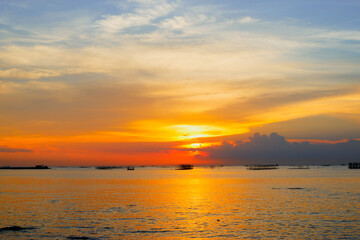 sunset in the sea. Beautiful colorful sky and cloud in twilight time background. Orange fluffy clouds and sun sunlight reflection in the blue sky.