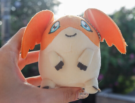 Tokyo, Japan - August 29, 2025 - Caucasian hand holding a plush toy of the character "Patamon" from the Japanese animation series "Digimon"
