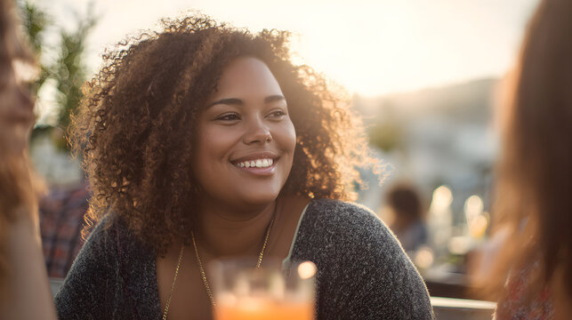 Plus size woman smiling with friends outdoors in sunset  