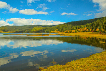 Fototapeta premium Colorful hills and blue lakes create a serene panorama Pudacuo National Park, Yunnan, China, Shangri-La