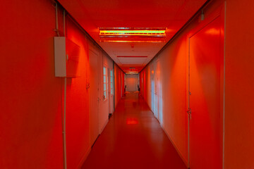 Dramatic red-lit hallway creating intense atmospheric interior lighting effect