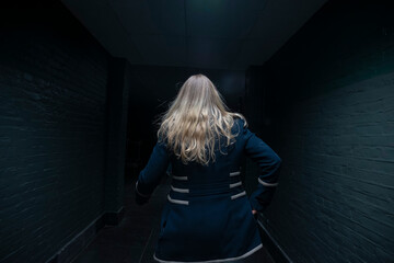 Blonde woman in dark underground tunnel creating dramatic atmospheric portrait lighting