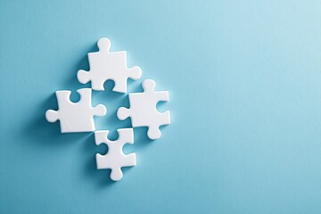 Four white puzzle pieces arranged on a light blue surface