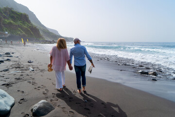 lifestyle with caucasian senior couple walking on beach, happy in love romantic and relax time, tourism of elderly family pleople, leisure and activity travel after retirement in vacations and summer