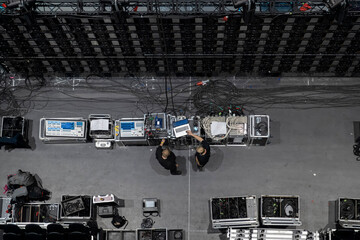 Aerial view of production crew operating control equipment and monitors during concert setup